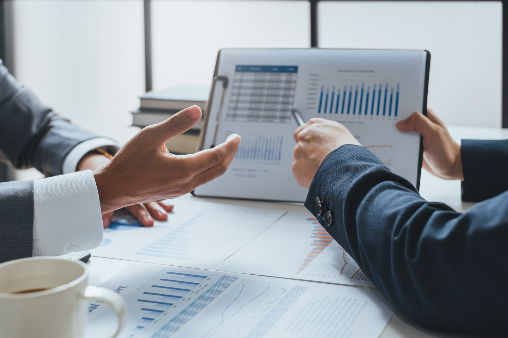 Geschäftsleute treffen sich und arbeiten mit Finanzberichten, sprechen über Geschäftspläne für Investitionen und über Konzepte der Finanzanalyse.